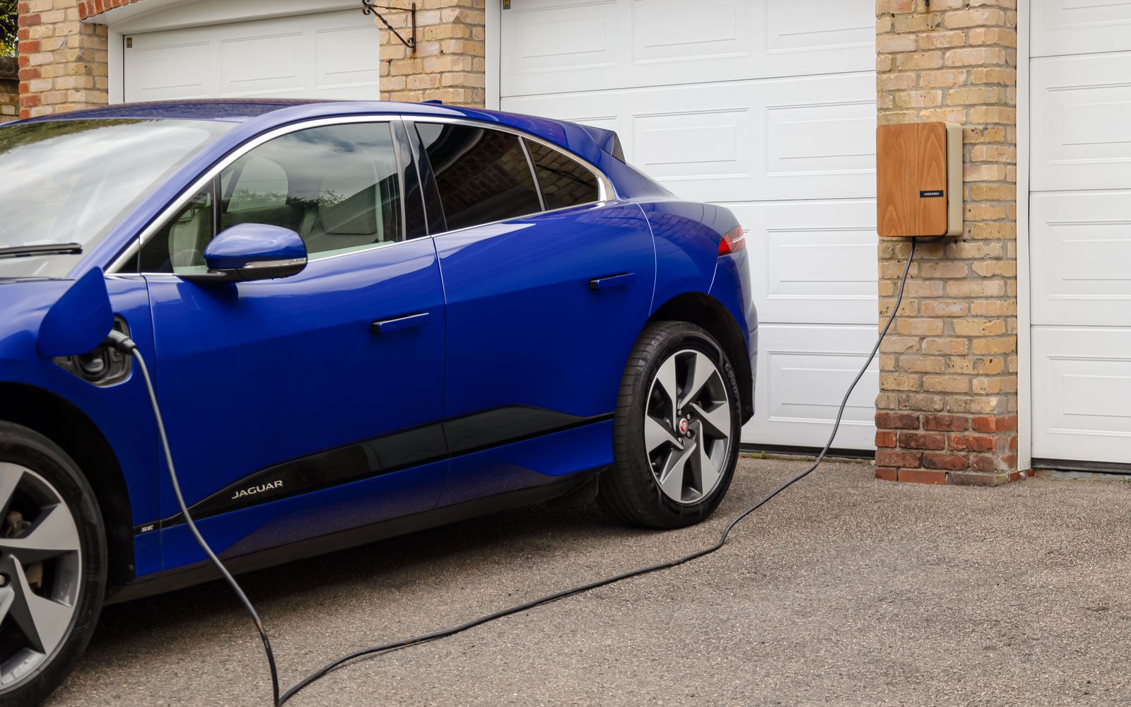Electric car plugged into a wall-mounted home charger