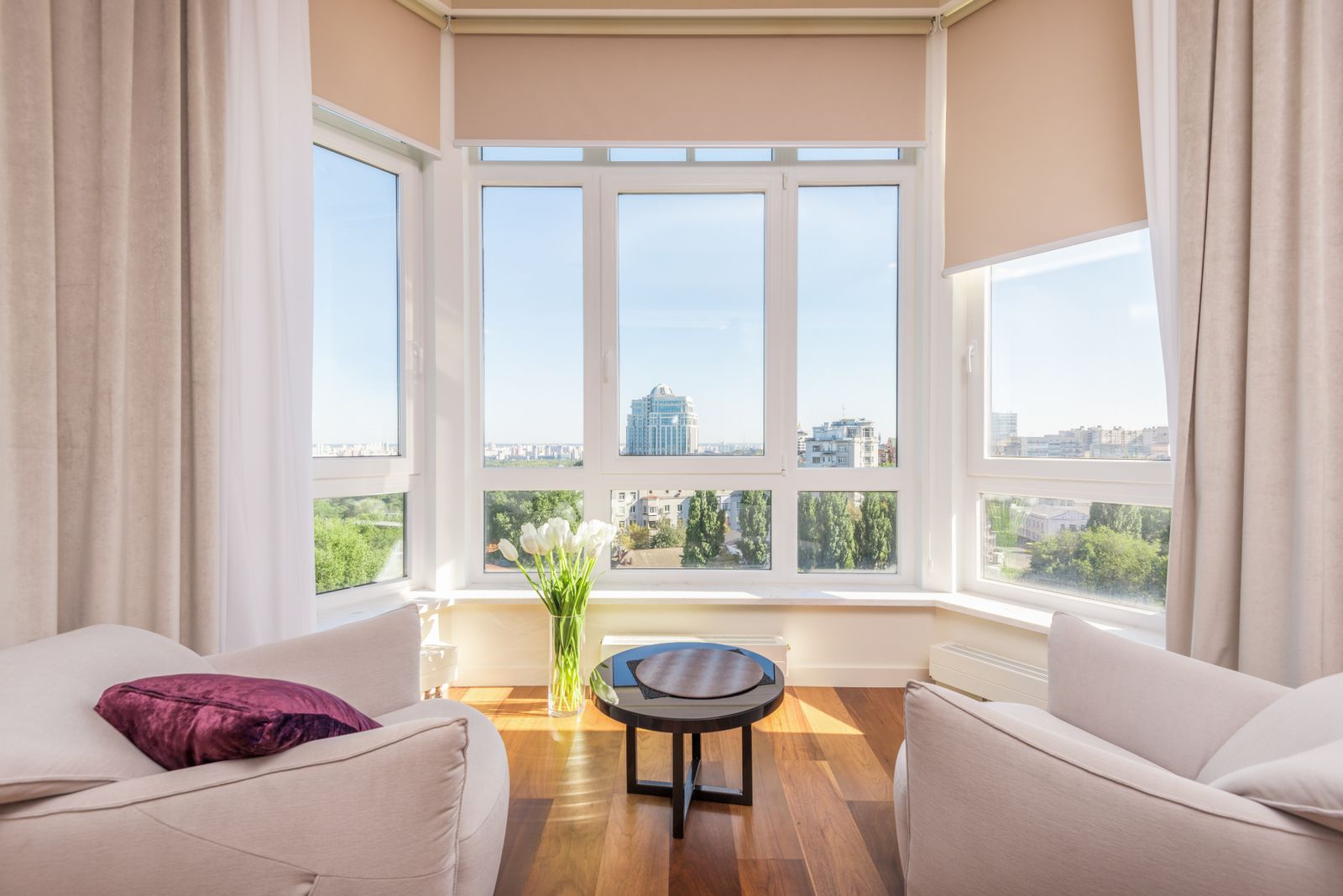 Bright living room with a wide bay of white-framed windows