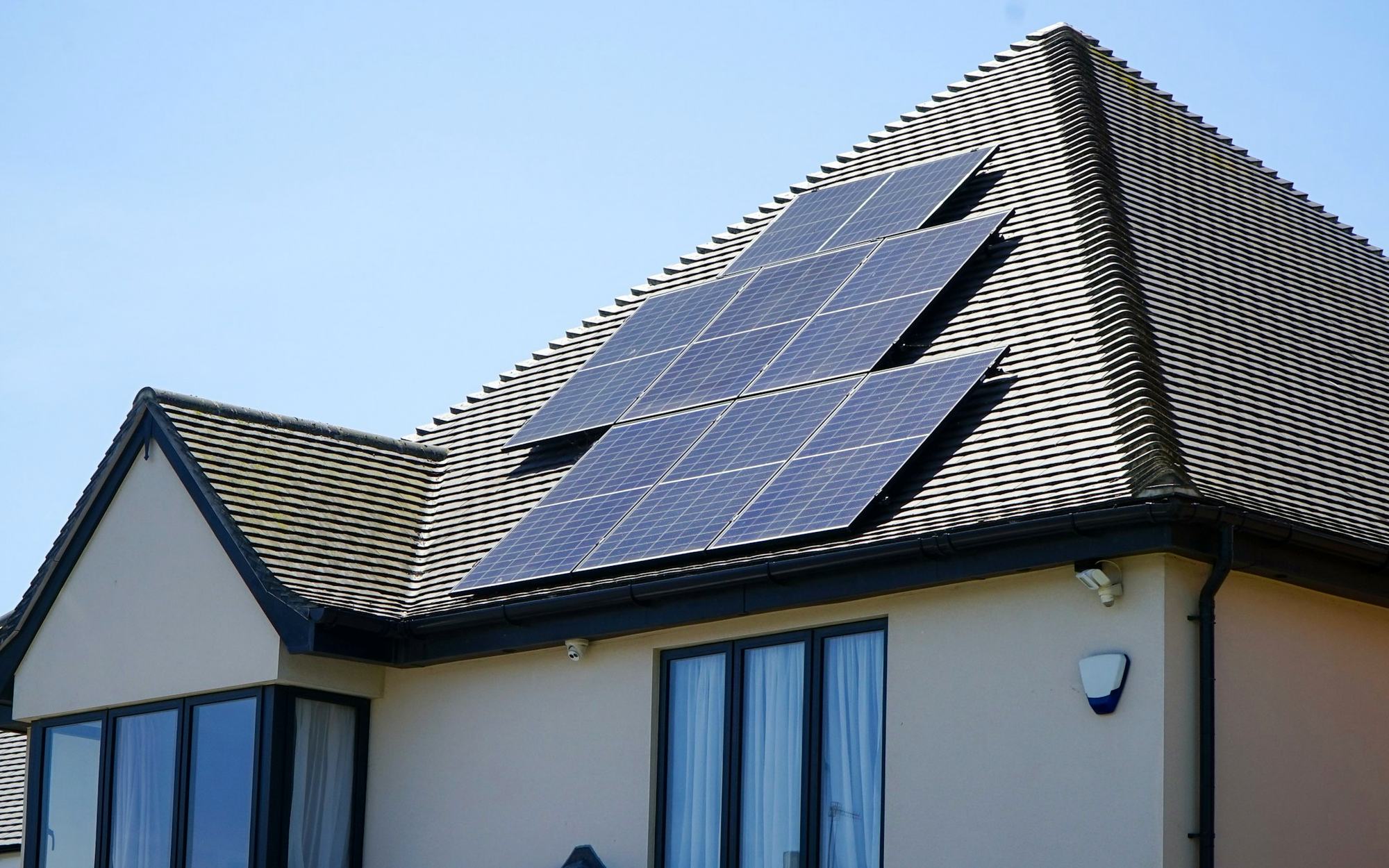 Modern home with a large array of black solar panels on the roof