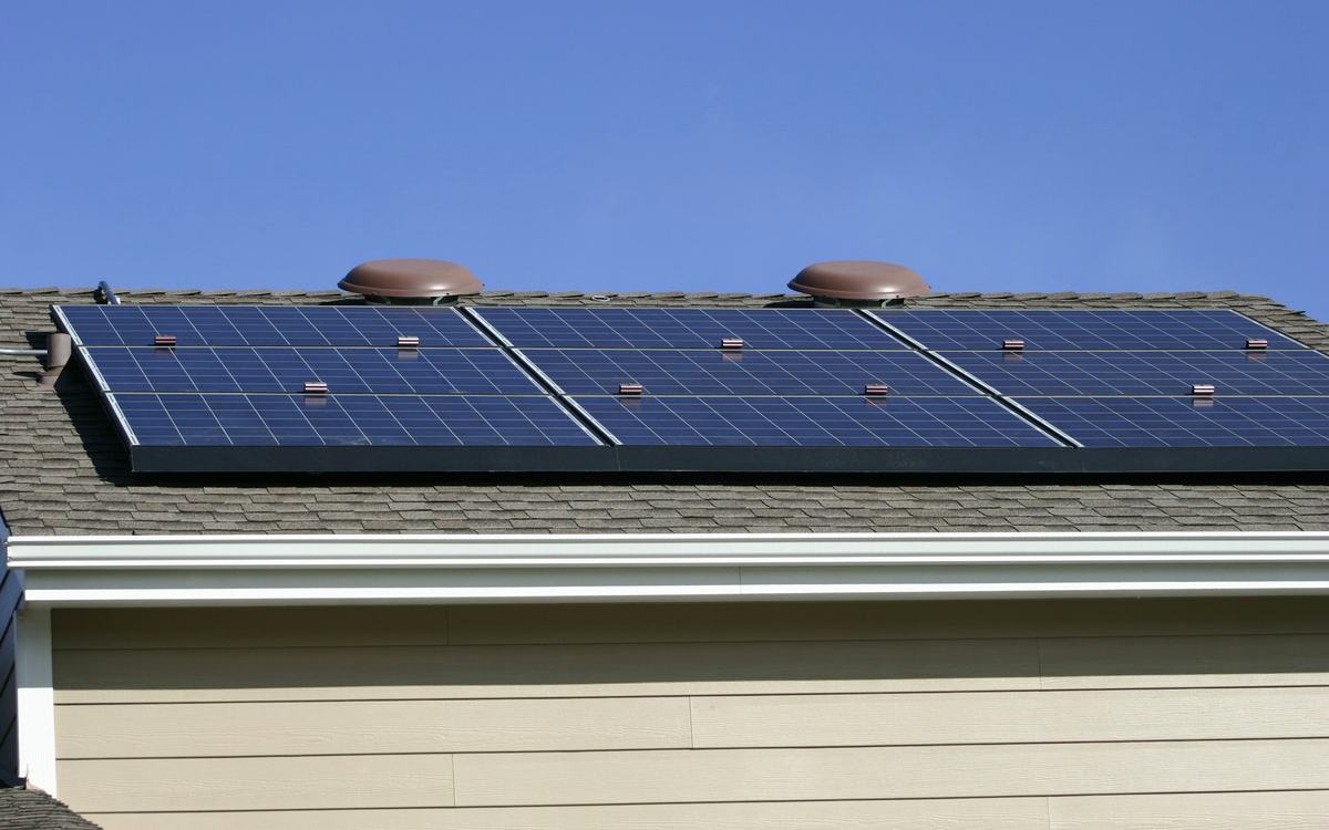Solar panels on a home roof under blue sky